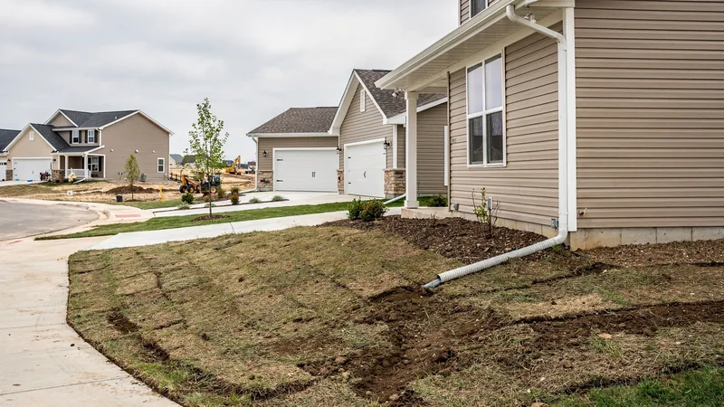 Downspout extension and regraded soil along a newer Ankeny, IA home